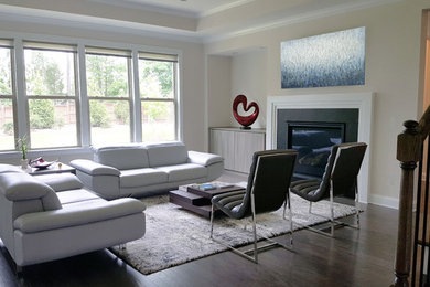 Example of a transitional open concept dark wood floor living room design in Raleigh with gray walls and a standard fireplace