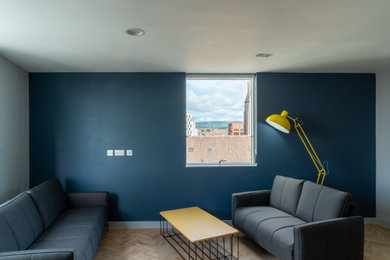 Foto de salón abierto actual de tamaño medio con paredes azules y suelo de madera en tonos medios