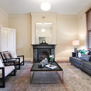 This is an example of a transitional formal open concept living room in Sydney with carpet, a standard fireplace, a stone fireplace surround, no tv, beige walls and brown floor.