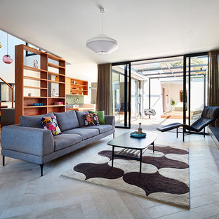 Diseño de salón abierto, contemporáneo, con suelo de baldosas de porcelana, chimenea tradicional, paredes beige, marco de chimenea de piedra y suelo beige