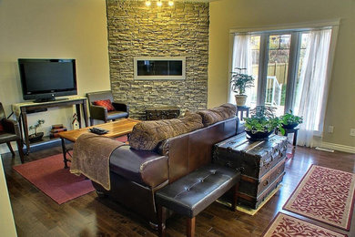 Стильный дизайн: изолированная гостиная комната среднего размера в классическом стиле с бежевыми стенами, темным паркетным полом, горизонтальным камином, фасадом камина из камня, отдельно стоящим телевизором и коричневым полом - последний тренд