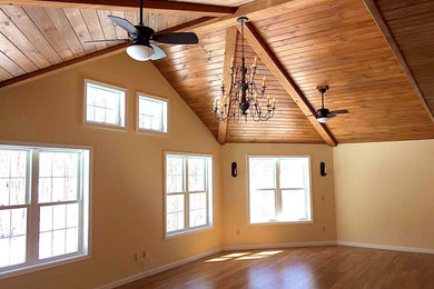 Ejemplo de salón cerrado de estilo americano grande con paredes amarillas y suelo de madera en tonos medios