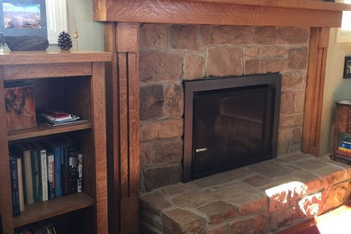 Arts and crafts medium tone wood floor living room photo in Other with green walls, a standard fireplace and a stone fireplace