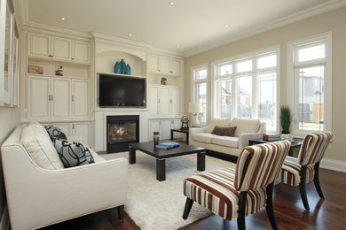 Example of an arts and crafts light wood floor and brown floor living room design in Toronto with white walls, a standard fireplace, a metal fireplace and a media wall