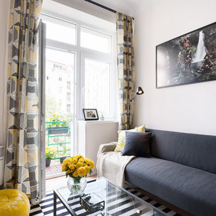 Inspiration for a small scandinavian open plan living room in London with white walls, laminate floors and a wall mounted tv.