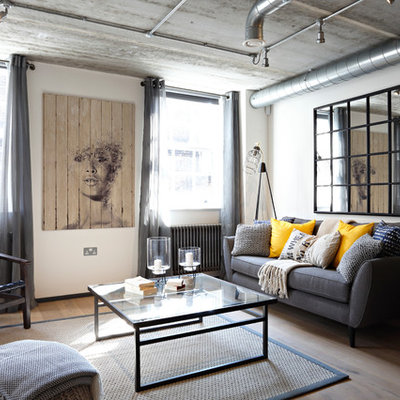 Living room - mid-sized industrial enclosed medium tone wood floor living room idea in London with no fireplace, no tv and white walls