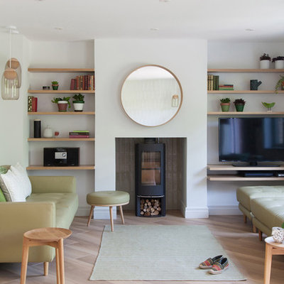 Living room - scandinavian formal and enclosed light wood floor and beige floor living room idea in Cambridgeshire with a wood stove and a tv stand