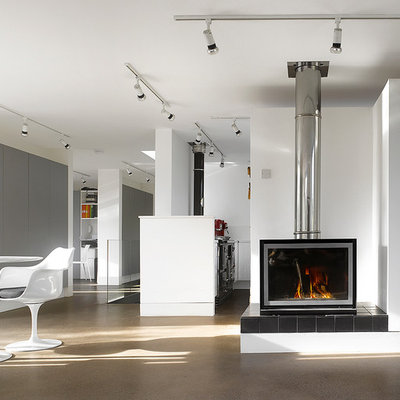 Example of a large trendy open concept concrete floor living room design in London with a wood stove