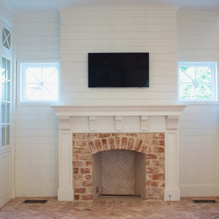 Mittelgroßes, Repräsentatives, Abgetrenntes Klassisches Wohnzimmer mit weißer Wandfarbe, Backsteinboden, Kamin, Kaminumrandung aus Backstein, Wand-TV und rosa Boden in Dallas