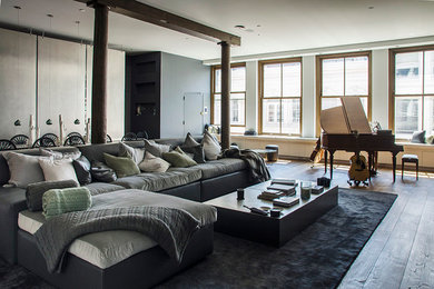Immagine di un grande soggiorno contemporaneo stile loft con pareti bianche e pavimento in legno massello medio