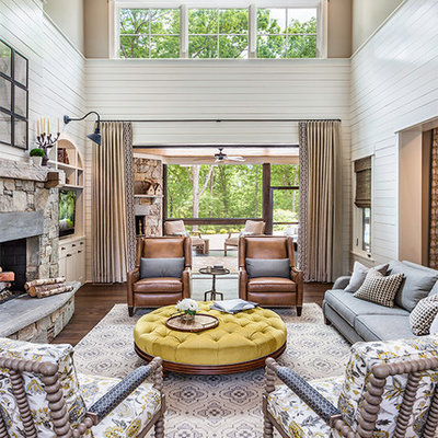 Inspiration for a large farmhouse open concept medium tone wood floor and brown floor living room remodel in Other with white walls, a standard fireplace, a stone fireplace and a media wall