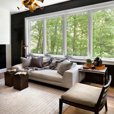 Living room - contemporary medium tone wood floor living room idea in New York with black walls