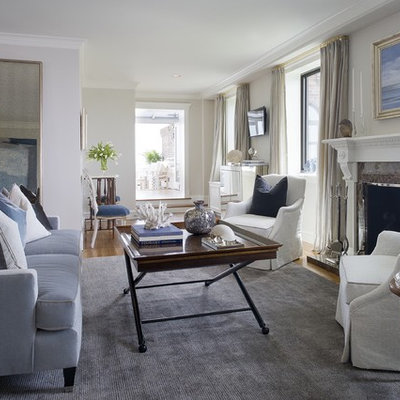 Example of a mid-sized transitional formal and enclosed medium tone wood floor living room design in New York with gray walls, a standard fireplace, a stone fireplace and no tv