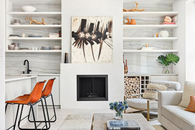 Foto de salón abierto minimalista pequeño con paredes blancas, suelo de cemento, todas las chimeneas, marco de chimenea de yeso, televisor colgado en la pared y suelo beige