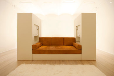 Imagen de salón abierto minimalista con paredes blancas y suelo de madera clara