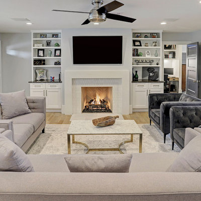 Mid-sized transitional enclosed light wood floor and beige floor living room photo in Houston with gray walls, a standard fireplace and a wall-mounted tv