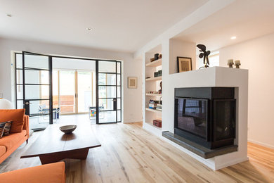 Example of a minimalist brown floor living room design in Chicago with white walls, a standard fireplace and a concrete fireplace