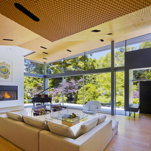 Idee per un soggiorno moderno chiuso e di medie dimensioni con sala della musica, camino classico, pareti bianche, parquet chiaro, cornice del camino in intonaco e nessuna TV