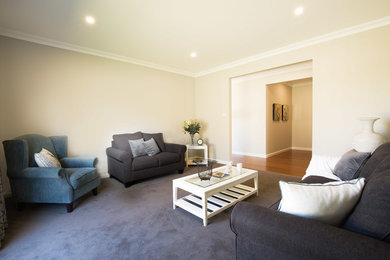 Mittelgroßes, Offenes Klassisches Wohnzimmer mit beiger Wandfarbe, Teppichboden und grauem Boden in Sonstige