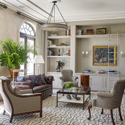 Living room library - tropical medium tone wood floor living room library idea in Miami with gray walls and no fireplace