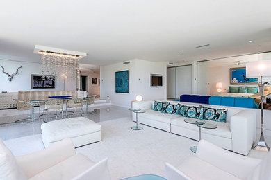 Example of a large trendy open concept porcelain tile and white floor living room design in Miami with white walls, no fireplace and a wall-mounted tv