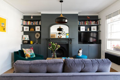 ロンドンにある高級な小さなトランジショナルスタイルのおしゃれなリビング (グレーの壁、無垢フローリング、標準型暖炉、壁掛け型テレビ、茶色い床) の写真