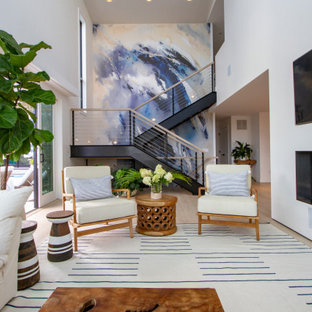 Example of a beach style open concept light wood floor and beige floor living room design in New York with white walls, a ribbon fireplace and a wall-mounted tv