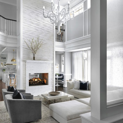 Inspiration for a large transitional open concept dark wood floor and brown floor living room remodel in St Louis with gray walls, a two-sided fireplace and a stone fireplace
