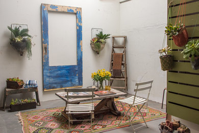 Foto de salón para visitas abierto rústico de tamaño medio sin chimenea y televisor con paredes blancas y suelo de cemento