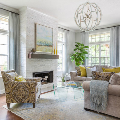 Example of a mid-sized transitional formal and open concept light wood floor and brown floor living room design in Jacksonville with gray walls, a standard fireplace and a stone fireplace