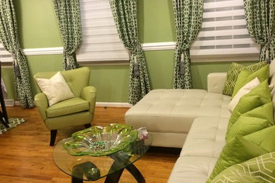 Diseño de salón minimalista con paredes verdes y suelo de madera clara