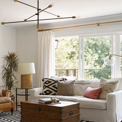 Example of a mid-sized transitional enclosed light wood floor living room design in Boise with white walls, a standard fireplace and a plaster fireplace