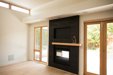 Example of a mid-sized trendy formal and open concept light wood floor living room design in Other with beige walls, a two-sided fireplace and a tile fireplace
