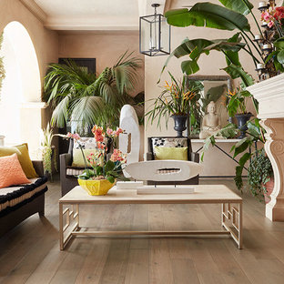 Inspiration pour un salon ethnique de taille moyenne et fermé avec une salle de réception, un mur beige, un sol en bois clair, une cheminée standard, un manteau de cheminée en pierre et aucun téléviseur.