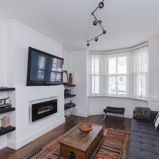 Photo of a medium sized contemporary enclosed living room in Oxfordshire with white walls, dark hardwood flooring, a ribbon fireplace, a plastered fireplace surround, a wall mounted tv and brown floors.