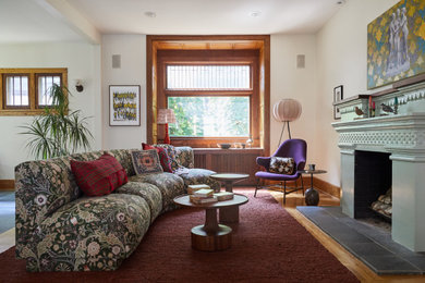 Klassisches Wohnzimmer mit weißer Wandfarbe, braunem Holzboden, Kamin und braunem Boden in Minneapolis