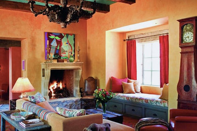 フェニックスにある高級な中くらいなラスティックスタイルのおしゃれなリビング (テレビなし、黄色い壁、コンクリートの床、標準型暖炉、石材の暖炉まわり) の写真