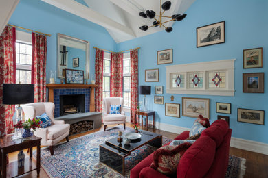 Ejemplo de salón abierto de estilo americano con paredes azules, suelo de madera oscura, todas las chimeneas, marco de chimenea de baldosas y/o azulejos y suelo marrón