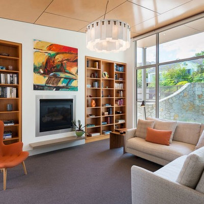 Mid-sized mid-century modern open concept carpeted and gray floor living room library photo in Melbourne with a standard fireplace, a plaster fireplace, white walls and no tv