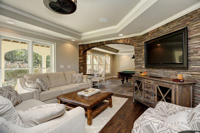 Diseño de salón para visitas abierto tradicional de tamaño medio con paredes beige, suelo vinílico, televisor colgado en la pared y suelo marrón