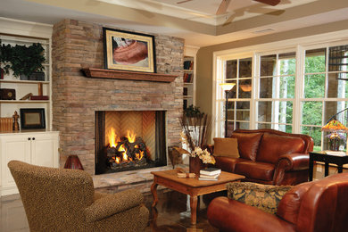 タンパにある中くらいなトラディショナルスタイルのおしゃれなリビング (ベージュの壁、コンクリートの床、標準型暖炉、石材の暖炉まわり、テレビなし、茶色い床) の写真
