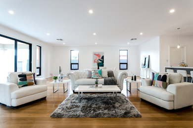 Imagen de salón abierto minimalista sin chimenea con paredes blancas y suelo de madera clara