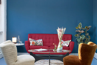 This is an example of a contemporary formal living room in London with blue walls and blue floors.