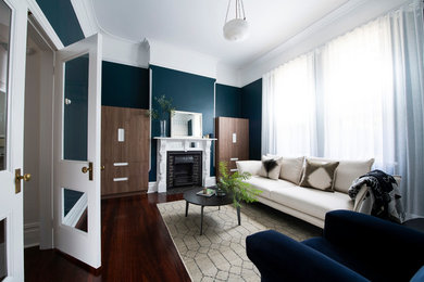 Mittelgroßes, Repräsentatives, Abgetrenntes Modernes Wohnzimmer mit grüner Wandfarbe, dunklem Holzboden, gefliester Kaminumrandung, Kamin und braunem Boden in Perth