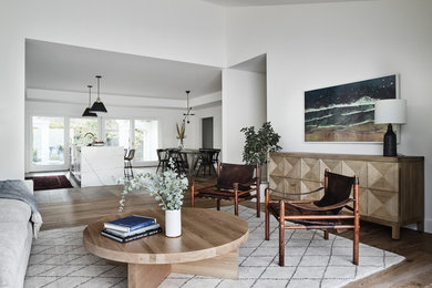 Example of a large trendy open concept medium tone wood floor and brown floor living room design in San Francisco with white walls and no tv