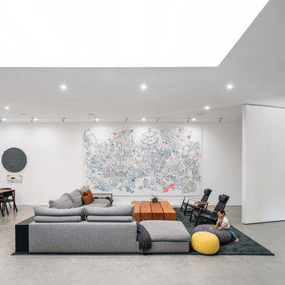 Living room - modern open concept concrete floor and gray floor living room idea in Los Angeles with white walls