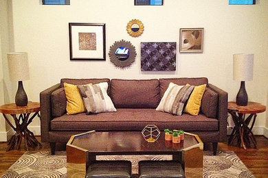 This is an example of an eclectic open plan living room in Denver with medium hardwood flooring, no fireplace and a wall mounted tv.