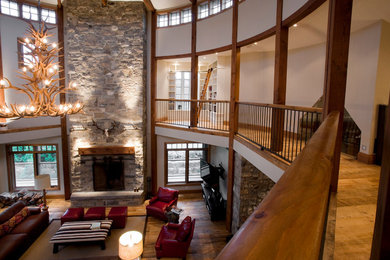 Example of a huge mountain style open concept medium tone wood floor living room design in Toronto with beige walls, a standard fireplace, a stone fireplace and a wall-mounted tv