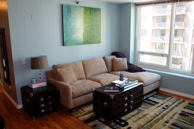 Imagen de salón abierto contemporáneo pequeño con paredes azules y suelo de madera en tonos medios