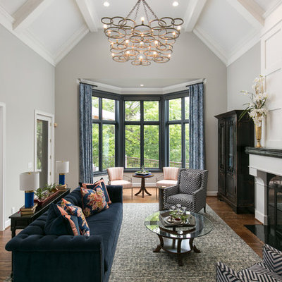 Example of a large classic formal medium tone wood floor and brown floor living room design in Kansas City with gray walls, a standard fireplace, a stone fireplace and no tv